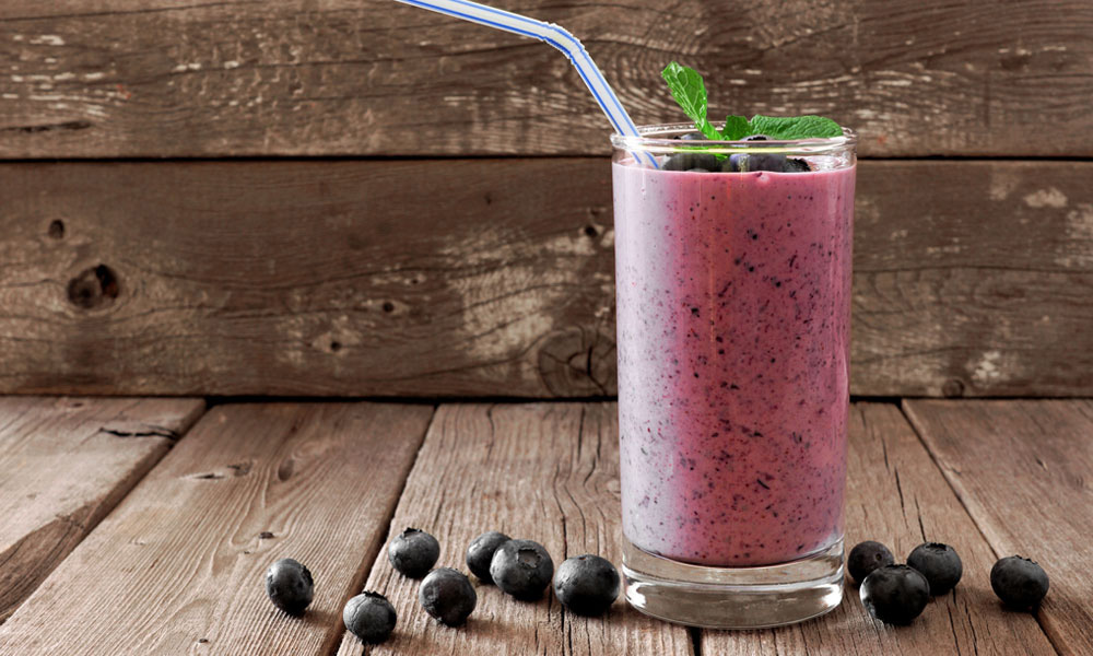 purple smoothie with straw and blueberries